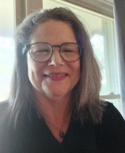 woman wearing glasses sitting in front of window