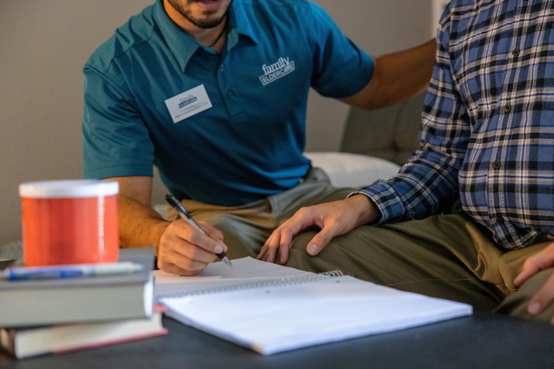 person with pen and paper next to another person